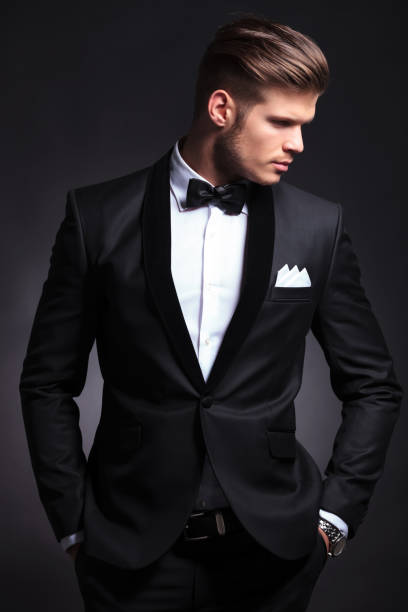 istock elegant man looks to side with hands in pockets 907679736