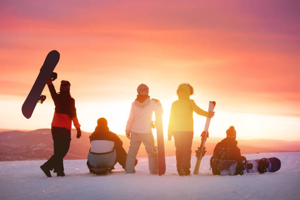 amici felici alla stazione sciistica contro il tramonto - snowboarding friendship snow winter foto e immagini stock