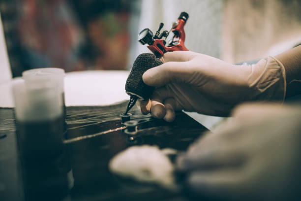 trabajo de arma del tatuaje - tattoo gun fotografías e imágenes de stock