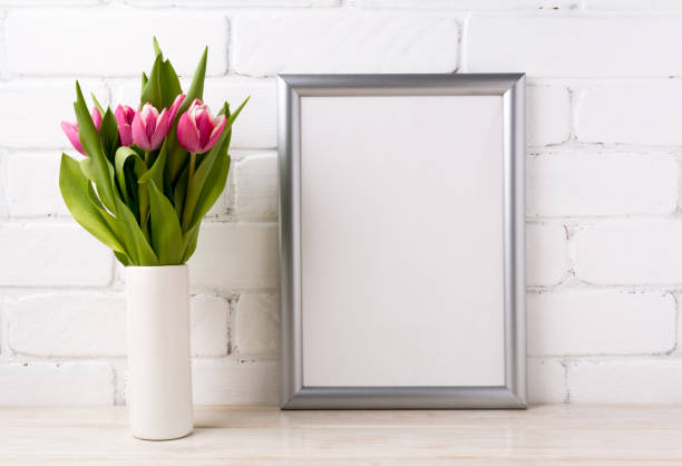 istock Silver frame mockup with pink tulips in vase 907694338