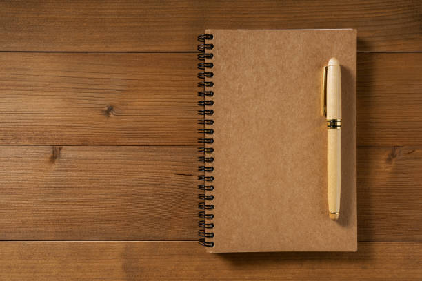istock High Angle View Of Diary With Pens On Wooden Table 907709012