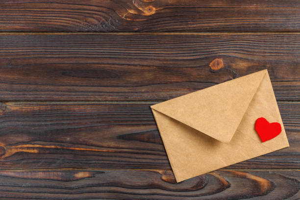 istock love letter envelope with red heart on wooden background. copy space 907726410