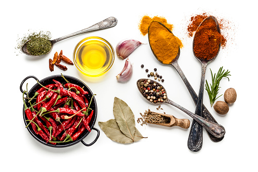 mixed herbs and spices and vegetables on white background