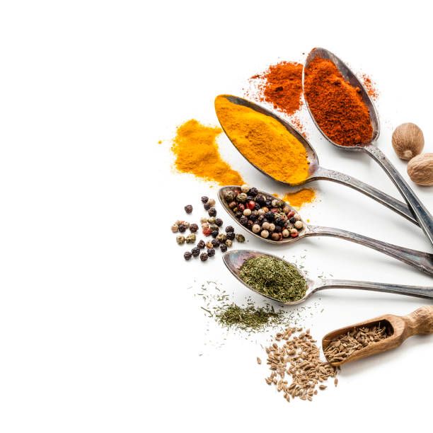 istock Spices and herbs in old spoons isolated on white background 907728716