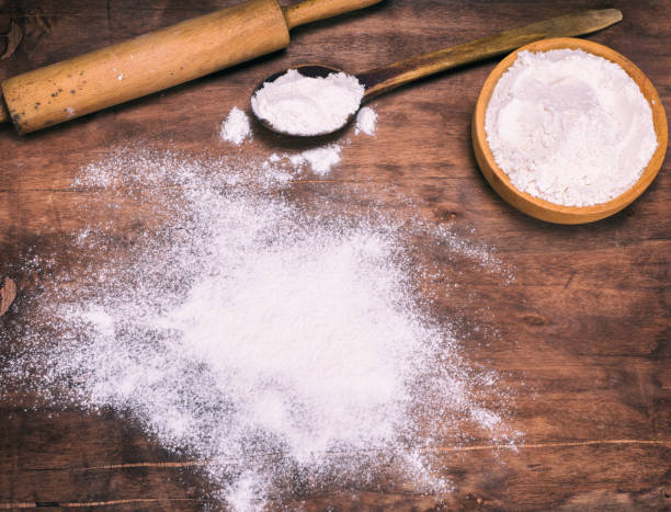 istock scattered white wheat flour on a brown wooden background 907741650