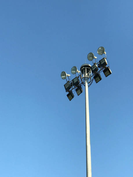 istock Football stadium spotlight pole on blue sky 907741888