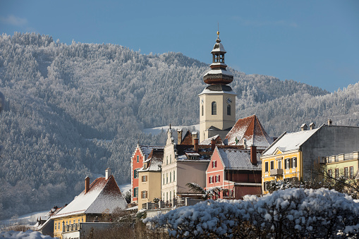 Panoramic view of beautiful winter wonderland mountain scenery in the Alps with pilgrimage church of Jamnik and famous Julian Alps in the background, Slovenia Christmas time in Europe