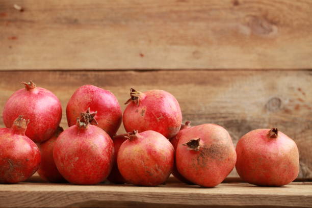 istock pomegranates on a wooden table 907758590