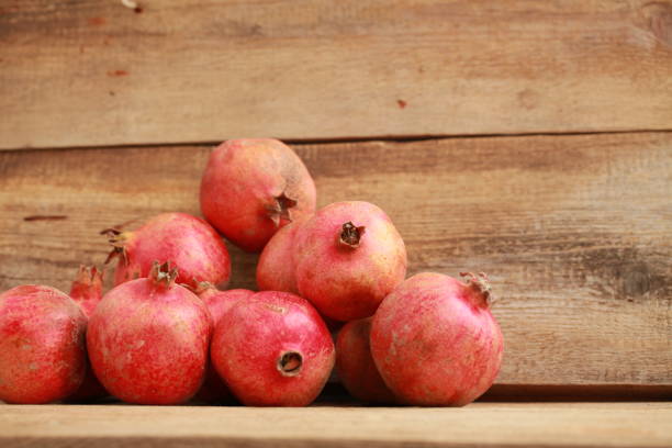 istock pomegranates on a wooden table 907758736