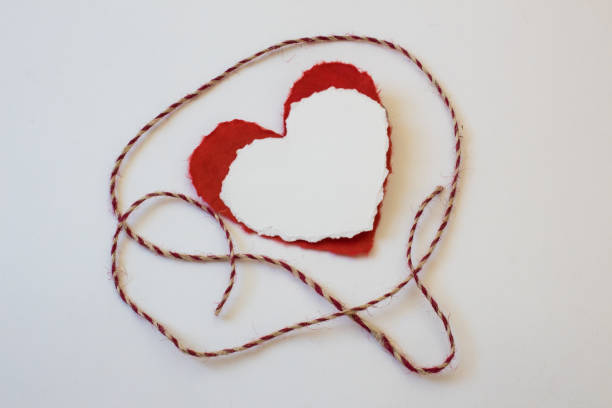 istock Torn white and red valentine hearts with red and white twine 907776182