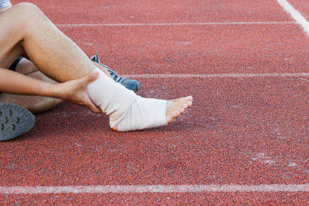istock Male athlete applying compression bandage onto ankle injury 907781536