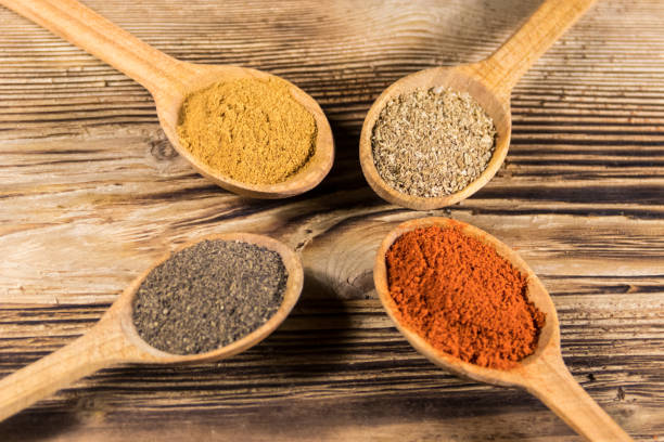 istock Assorted spices in wooden spoons on a table 907816166