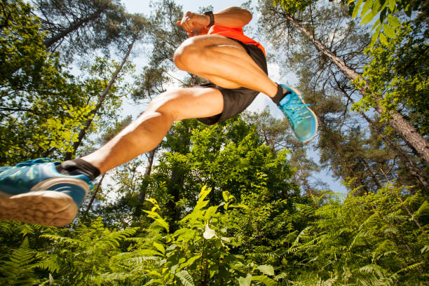 istock Runner jumping over the camera in the forest 907816434