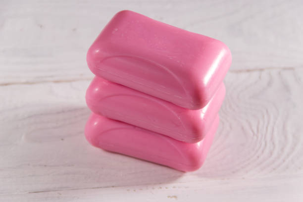 istock Stack of three pink soap on white wooden background 907816826