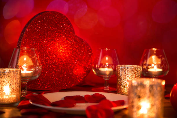 istock Valentine's Day romantic candlelight dinner with heart and rose petals. 907819950