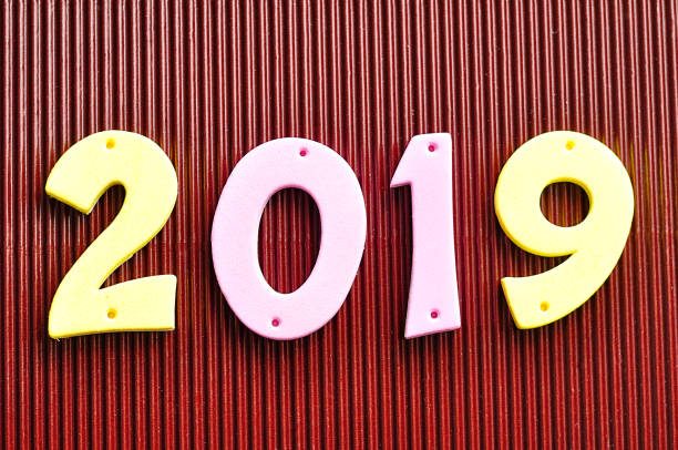 istock 2019 in pink and yellow numbers on a brown background 907830694