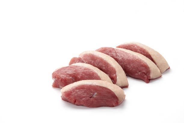 Raw duck breast pieces isolated on white background Raw duck breast pieces with skin isolated on white background duck meat stock pictures, royalty-free photos & images