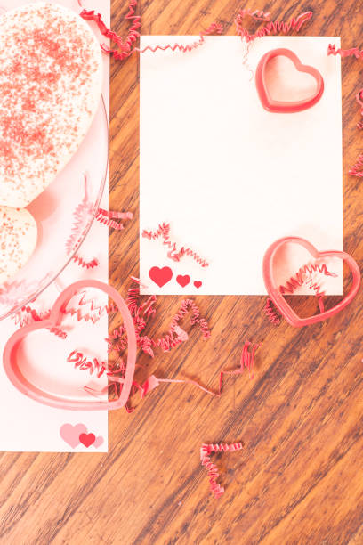 istock Valentine's Day cookies and cutters with blank paper. 907834180