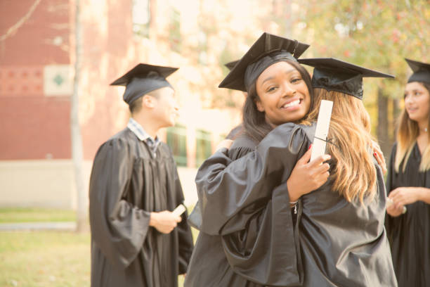 istock College student friends excitedly hug after graduation ceremony. 907837662