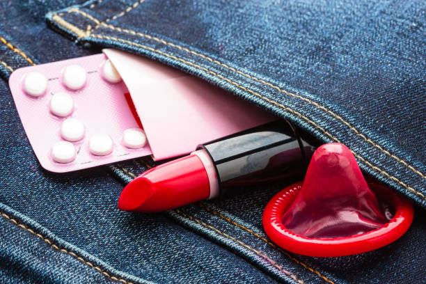 pilules préservatif et rouge à lèvres dans la poche de jeans. - sex condom jeans horizontal photos et images de collection