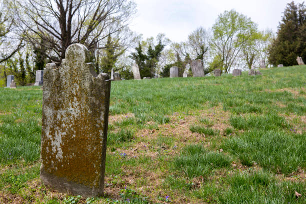 istock Very old grave headstone on a hill with graveyard in the background 907838002