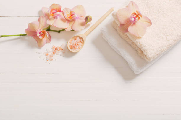 istock orchid with towels on white wooden background 907838476