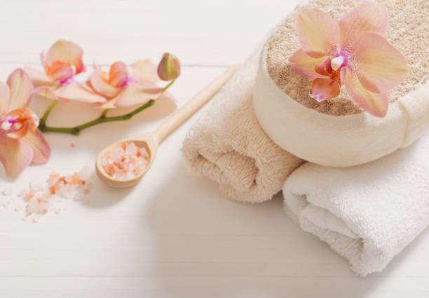 istock orchid with towels on white wooden background 907838478