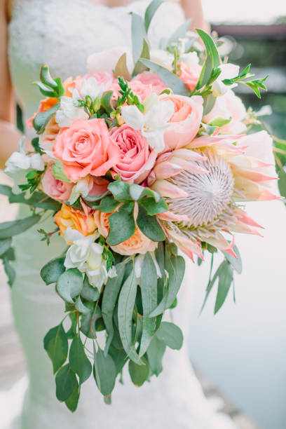 istock Bride holds a bouquet with proteus and roses. Wedding day 907844708