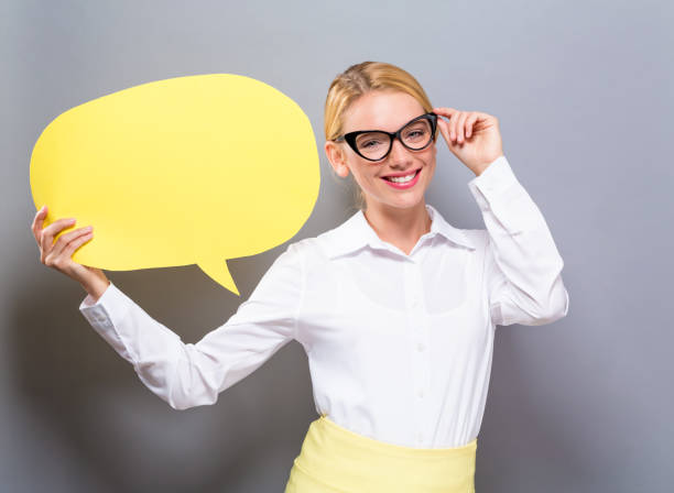 istock Young woman holding a speech bubble 907844754