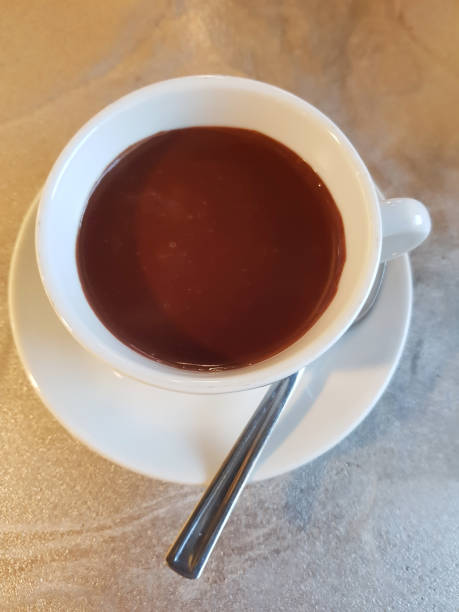 istock Hot chocolate, hot cocoa in white cup on table top view. 907846452