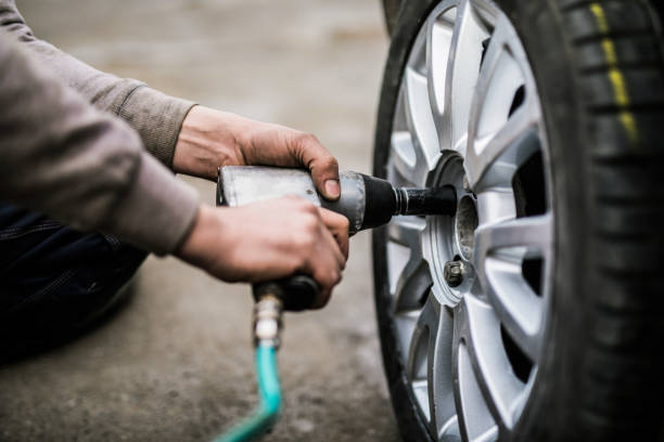 istock Mechanic putting new wheels on a car using a handgun. 907847766
