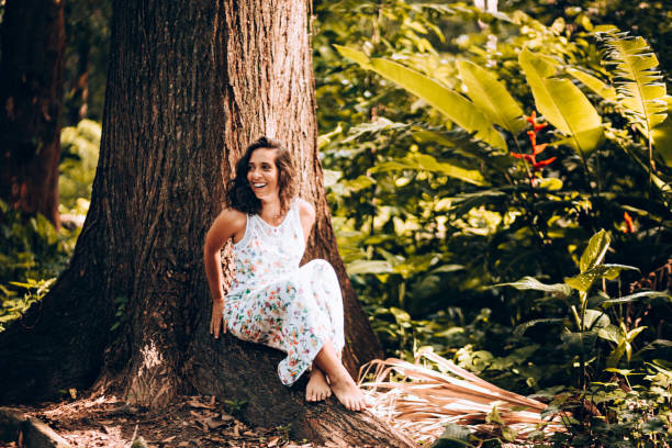 istock Young woman sitting by the tree 907847992