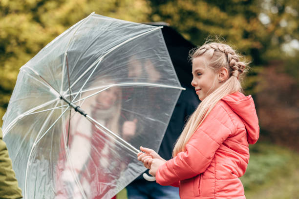 istock parents and daughter with umbrellas 907848404