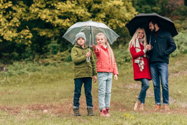 istock parents and kids with umbrellas 907848626