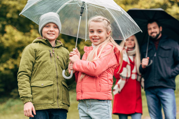 istock parents and kids with umbrellas 907848740