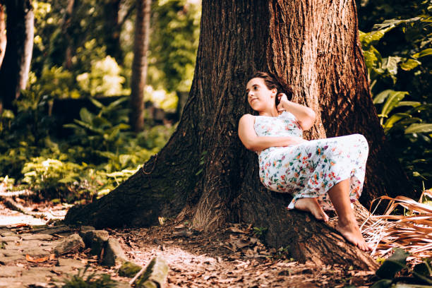istock Young woman lying by the tree 907848868