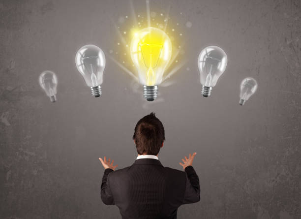 istock Business person having an idea light bulb concept 907849640