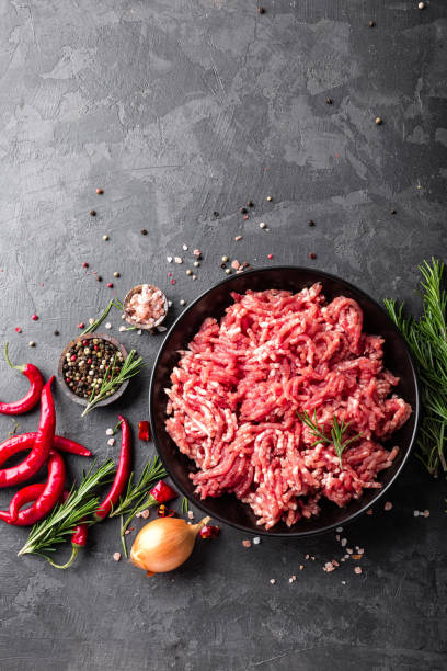 istock Mince. Ground meat with ingredients for cooking on black background. Top view 907850094