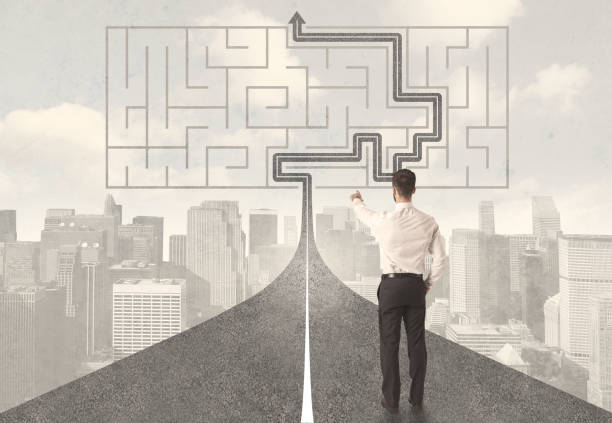 istock Businessman looking at road with maze and solution 907850280