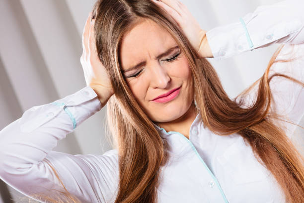 istock stressed woman in white shirt with headache 907850842