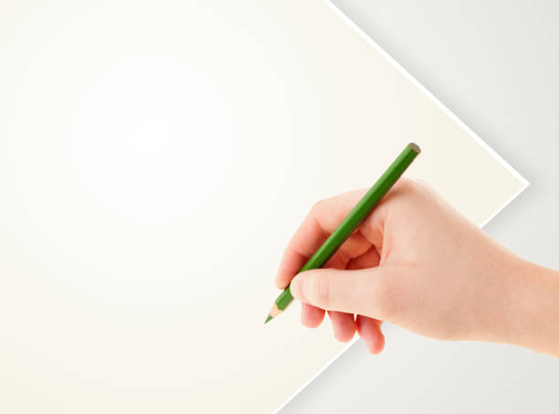 istock Human hand drawing with pencil on empty paper template 907851608