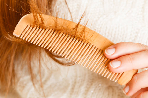 istock Female hand combing long hair. 907852036