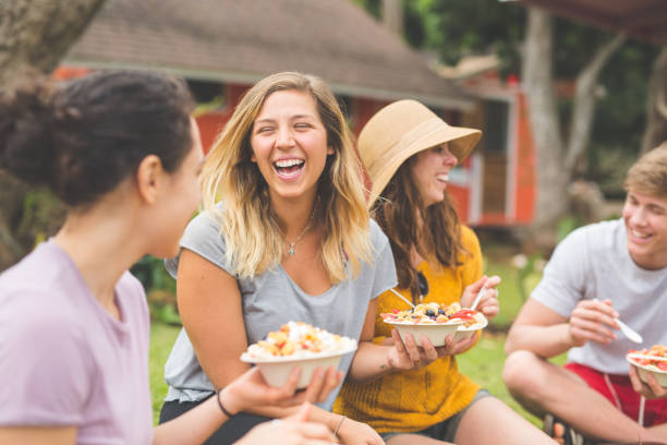 friends eating smoothie bowls topped with fresh tropical fruit - eating women breakfast cereal imagens e fotografias de stock