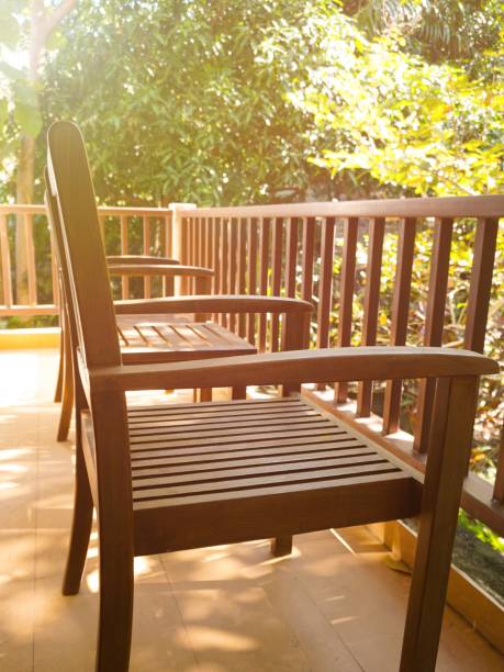 istock Two wooden chairs and one table on balcony in summer with natural trees background. 907852450