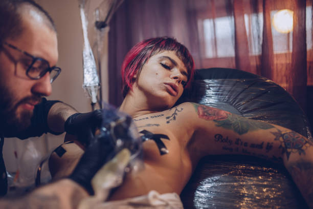 istock Man tattooing a woman 907853262