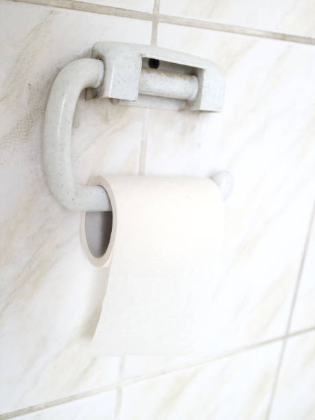 istock toilet paper on a tiled wall 907856044