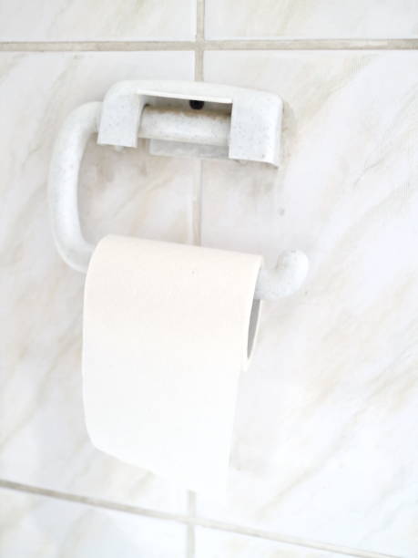 istock toilet paper on a tiled wall 907856132