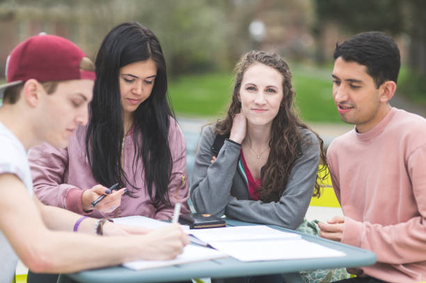 istock Multiethnic group of college students study outside at table together 907856164