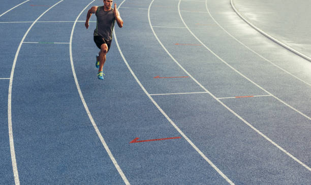 sprinter läuft auf strecke - tartanbahn stock-fotos und bilder