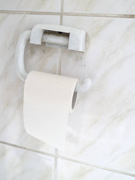 istock toilet paper on a tiled wall 907856308
